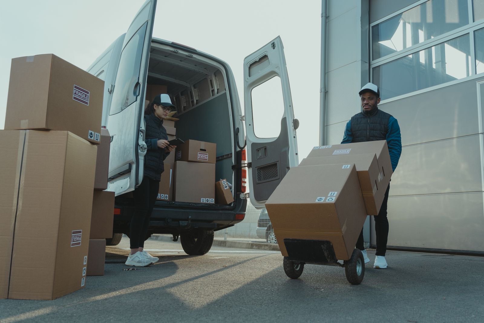 Workers loading palletized parcels into a delivery truck